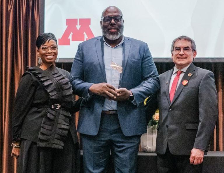 Devon Gilchrist, MSW (center) accepts his distinguished alumni award with Joan Blakey, PhD (left) and Dean Michael Rodriguez, PhD (right).