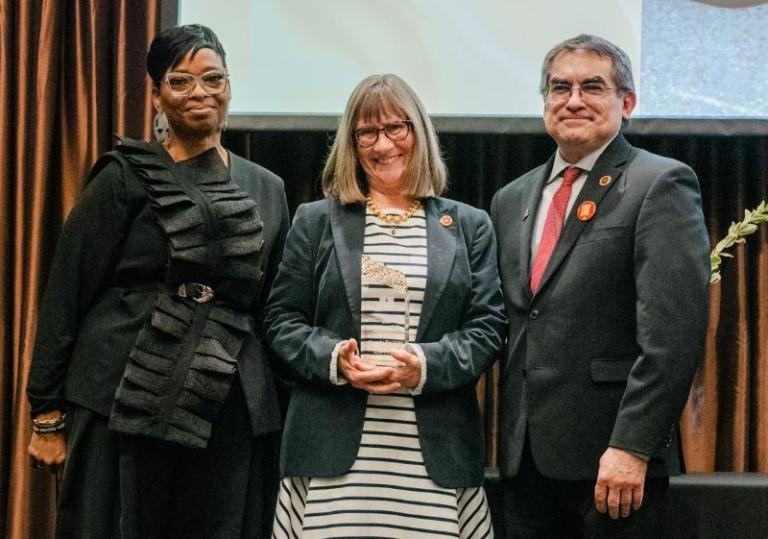 Brenda Hartman, MSW (center) accepts his distinguished alumni award with Joan Blakey, PhD (left) and Dean Michael Rodriguez, PhD (right).