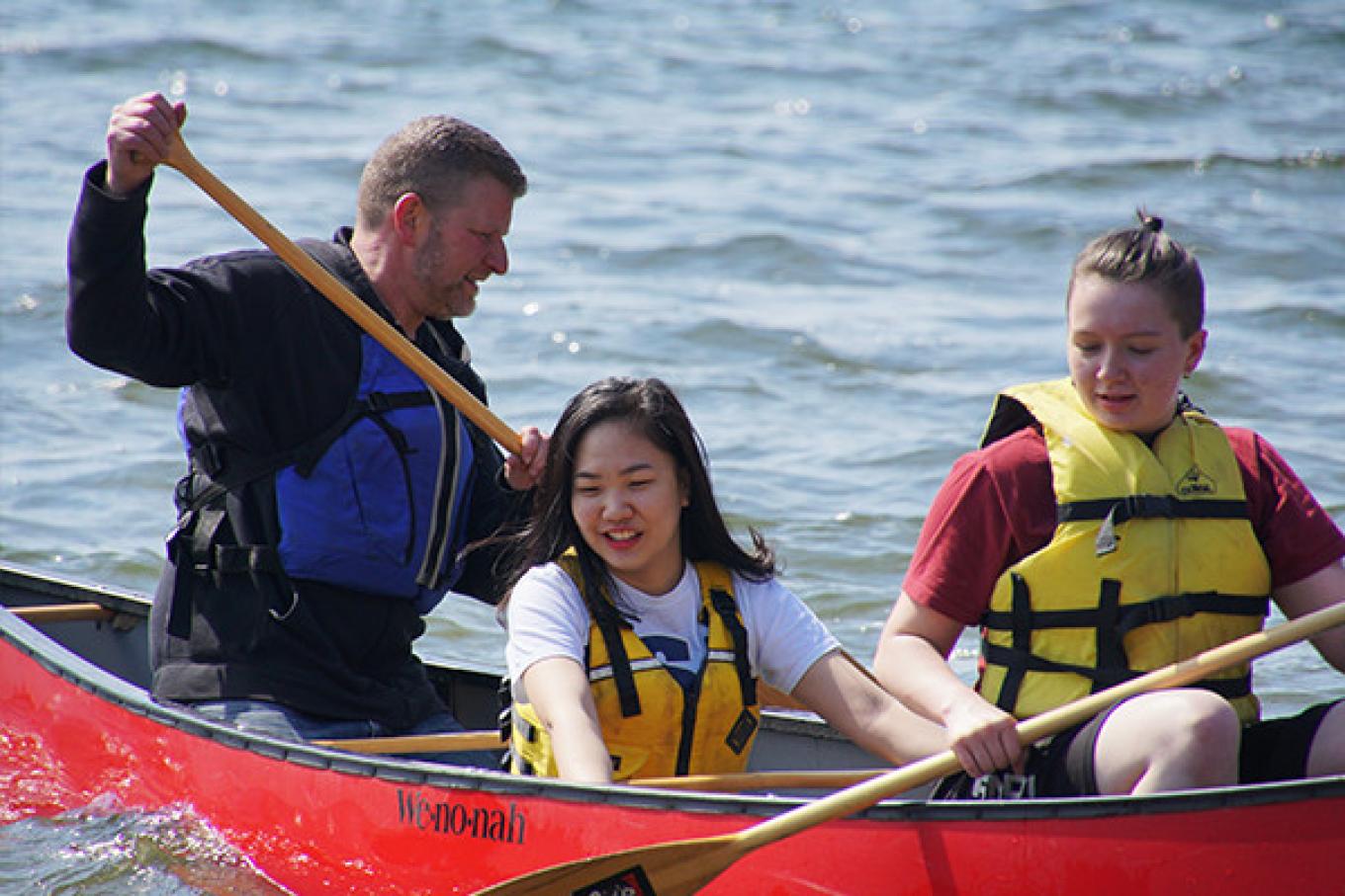 Students canoeing Bde Maka Ska durnig a Youth Studies Experiential Learning class.