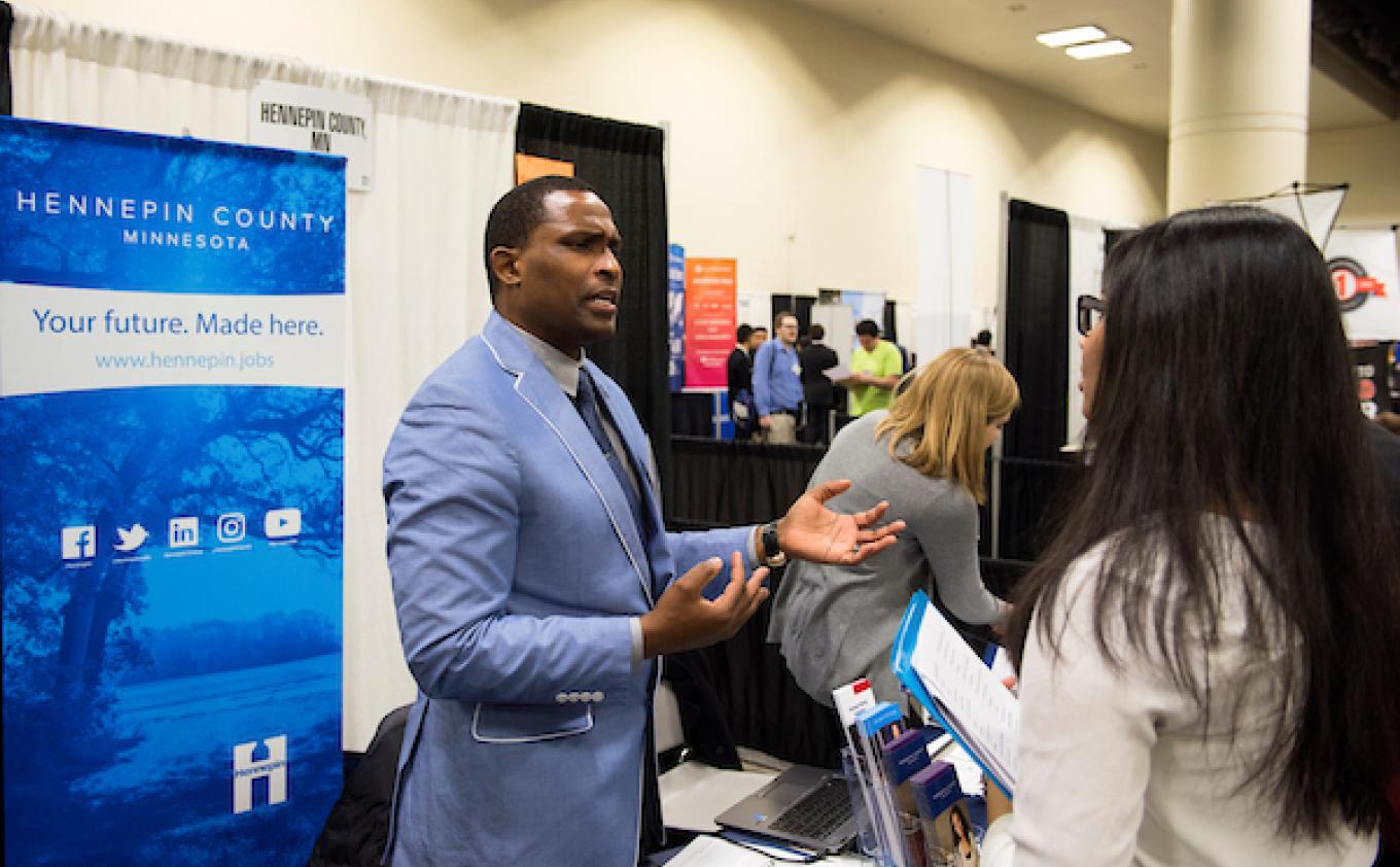 A Hennepin County recruiter talks to a job seeker at a UMN job fair.