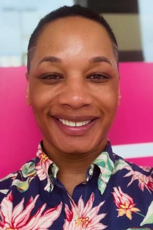 Tysen Tyson, PhD Candidate, smiles in a professional portrait wearing a flowered shirt.